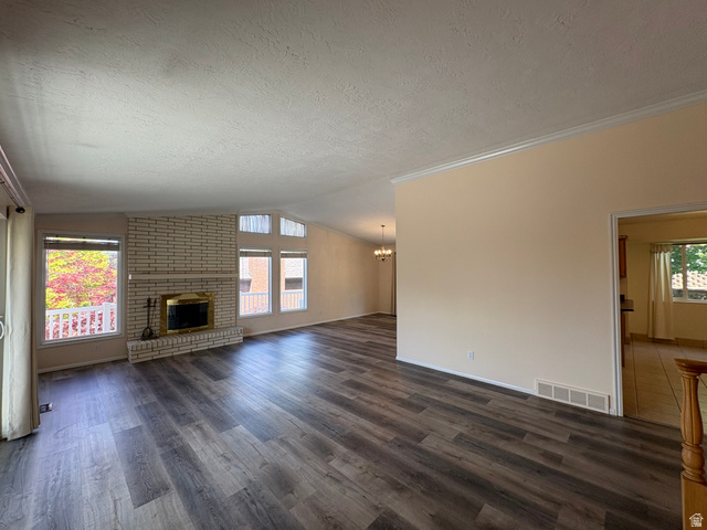 595 Meadowlark Road Orem, UT 84097 - Photo 4 of 87 Spacious living area featuring contemporary wood-finish flooring, a white brick fireplace with a brass-trimmed insert, and large windows with transom architectural details