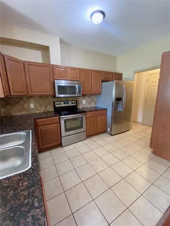 a kitchen with stainless steel appliances a stove a sink cabinets and a counter top space