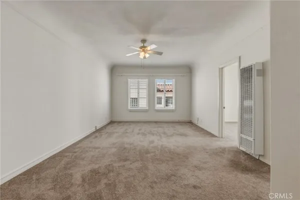 an empty room with windows and ceiling fan