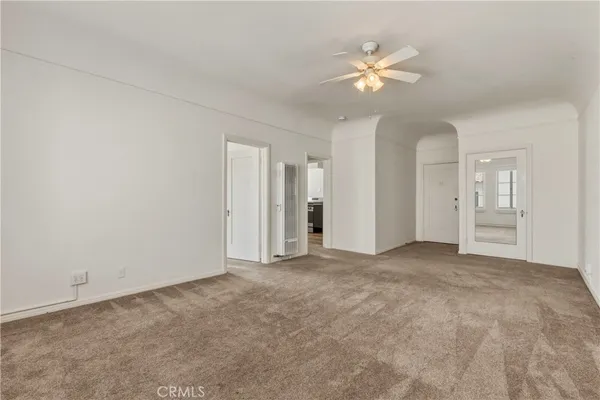 an empty room with closet and a ceiling fan