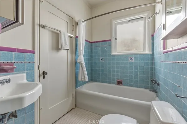 a bathroom with a tub shower sink and vanity