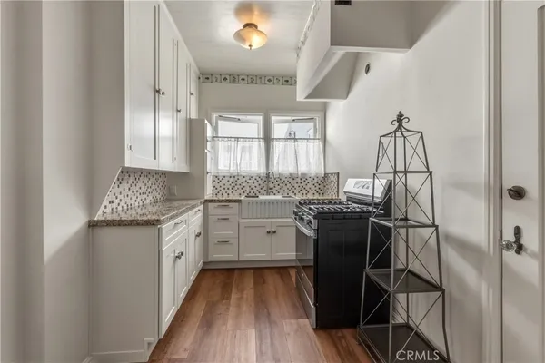 a kitchen with granite countertop white cabinets and stainless steel appliances