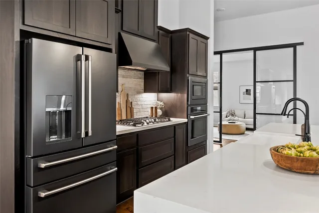 a kitchen with stainless steel appliances granite countertop a refrigerator and a stove