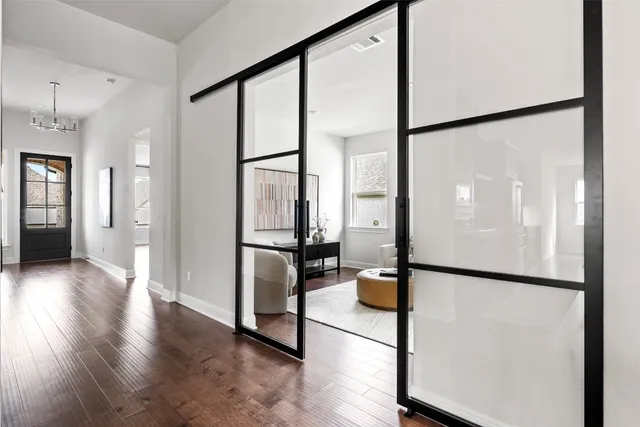 a view of a hallway with floor to ceiling window and a glass door