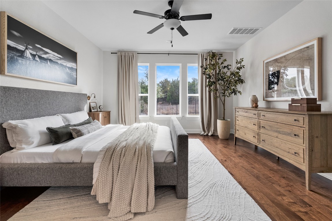 177 Running Bird Road Austin, TX 78737 - Photo 21 of 40 a bedroom with a large bed and a chandelier