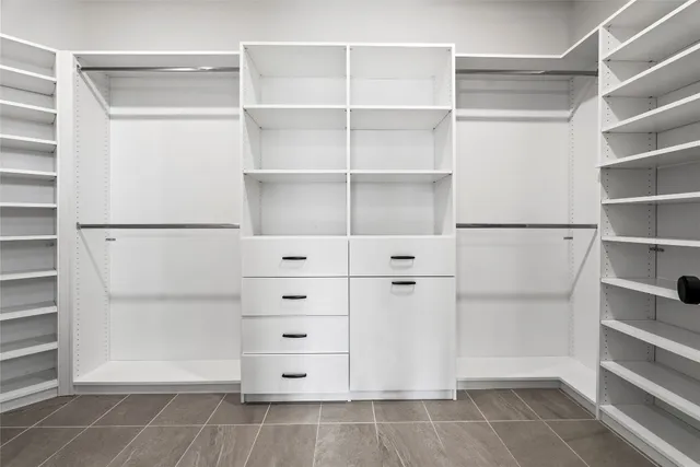 a view of walk in closet with empty racks