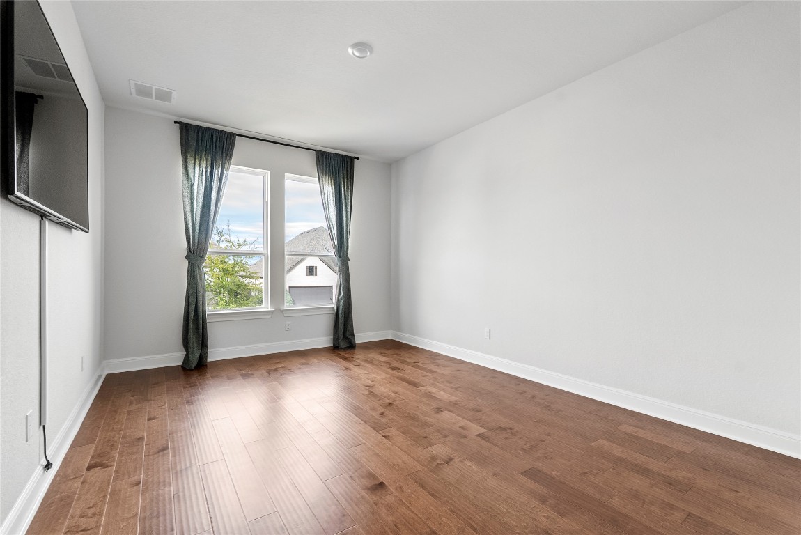 177 Running Bird Road Austin, TX 78737 - Photo 31 of 40 an empty room with wooden floor and windows