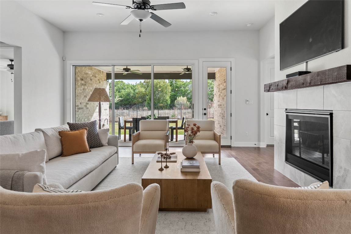 177 Running Bird Road Austin, TX 78737 - Photo 7 of 40 a living room with furniture a fireplace and a flat screen tv