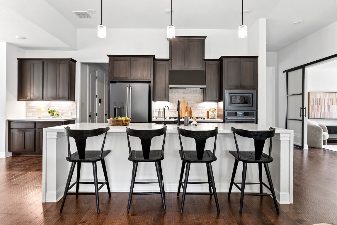 177 Running Bird Road Austin, TX 78737 - Photo 8 of 40 a dining area with stainless steel appliances kitchen island a table chairs and a refrigerator