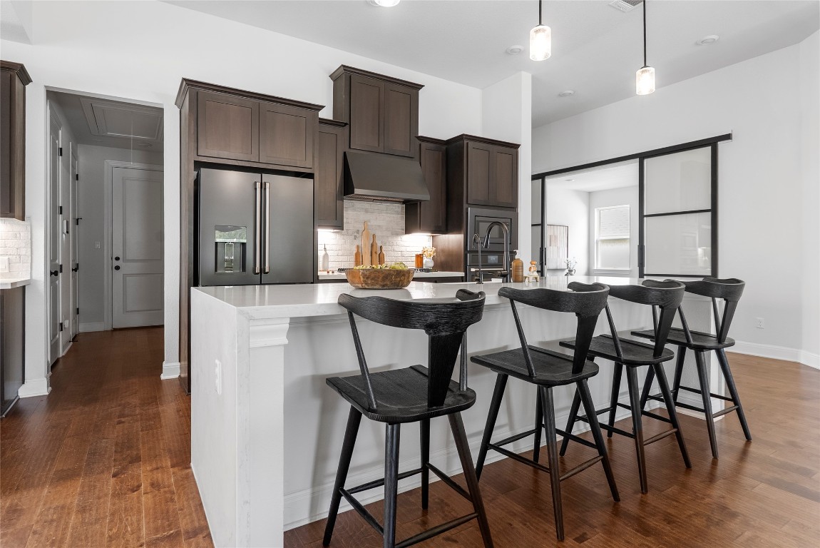 177 Running Bird Road Austin, TX 78737 - Photo 9 of 40 a kitchen with stainless steel appliances kitchen island granite countertop a dining table chairs and a refrigerator