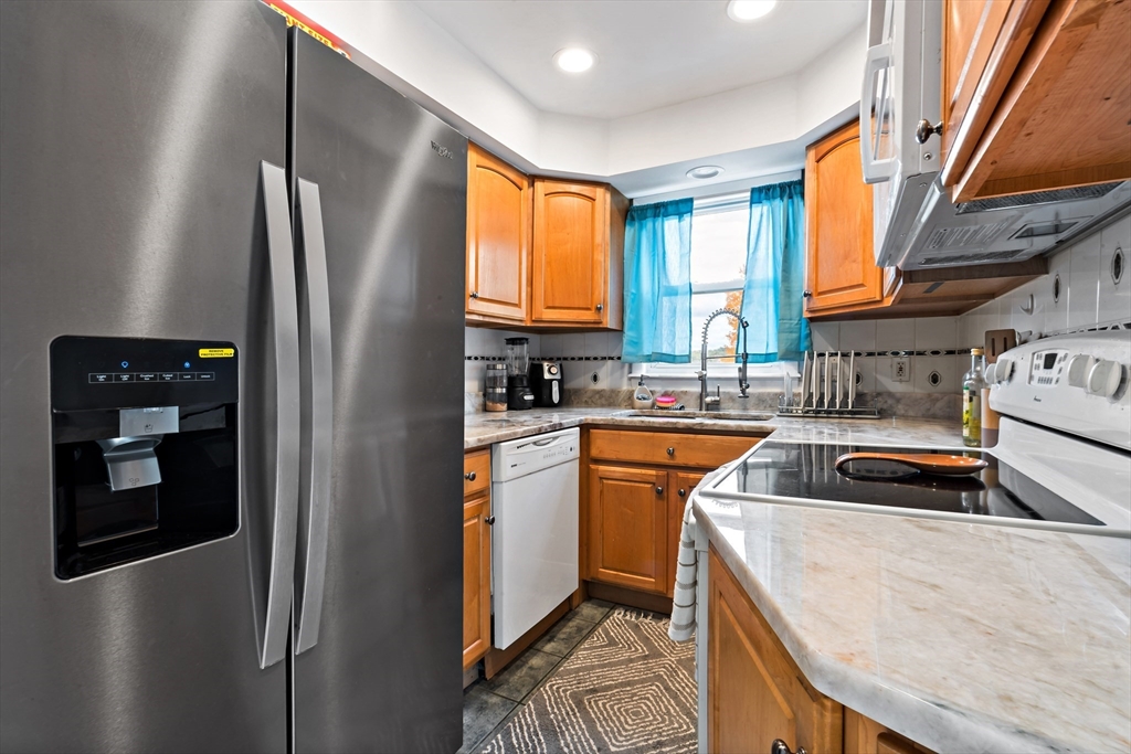 1000 Riverside Avenue Somerset, MA 02726 - Photo 25 of 26 a kitchen that has a sink a refrigerator and cabinets