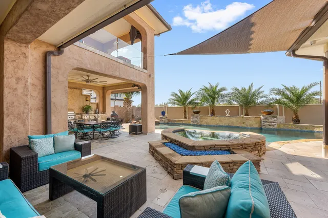 a swimming pool with outdoor seating and a potted plant