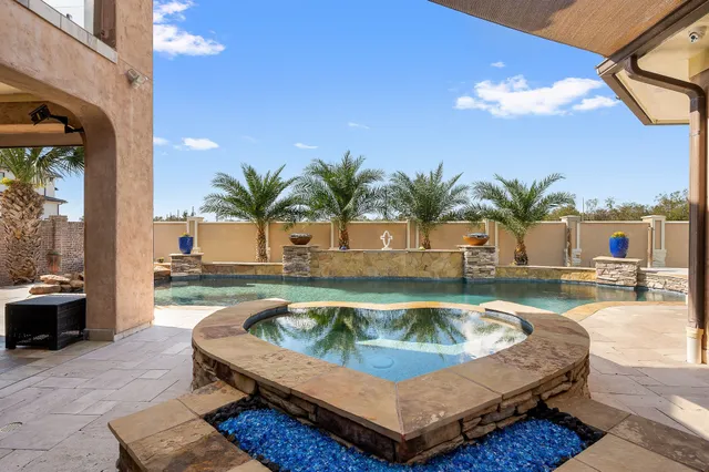 a view of a patio with table and chairs potted plants and palm tree