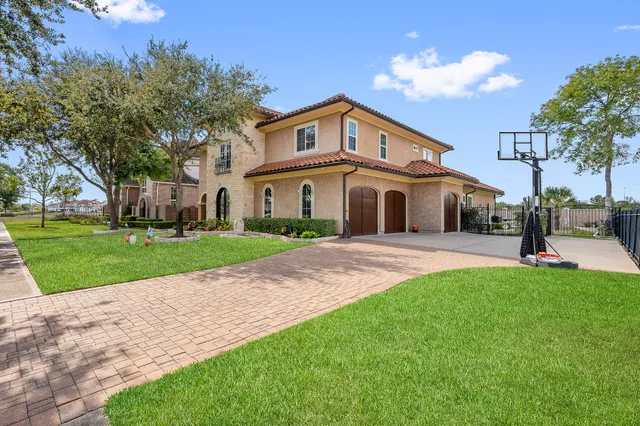 a white house with a big yard and large trees