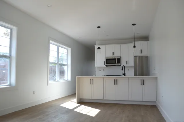 a kitchen with stainless steel appliances granite countertop a sink a microwave and wooden cabinets