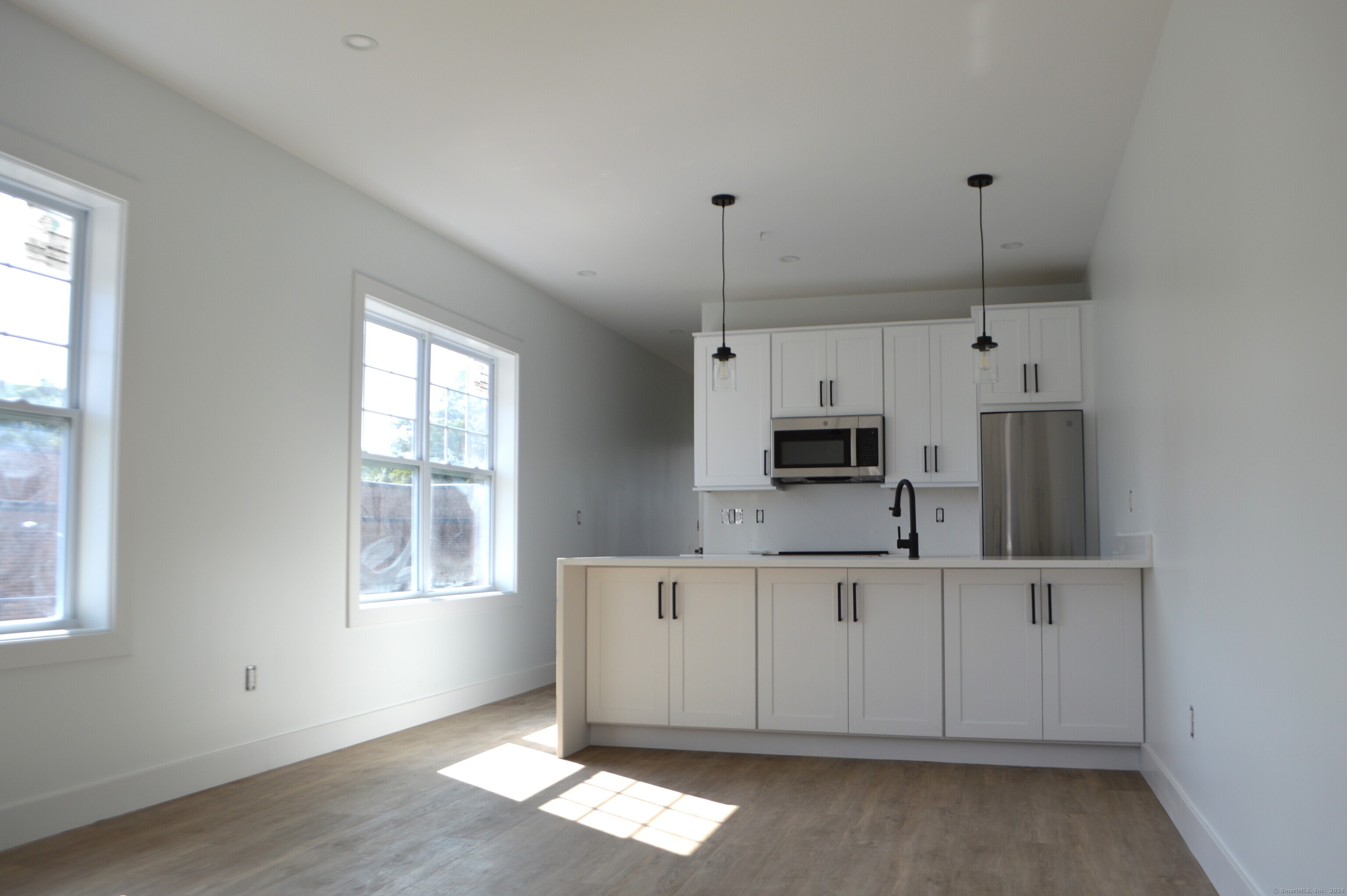 a kitchen with stainless steel appliances granite countertop a sink a microwave and wooden cabinets