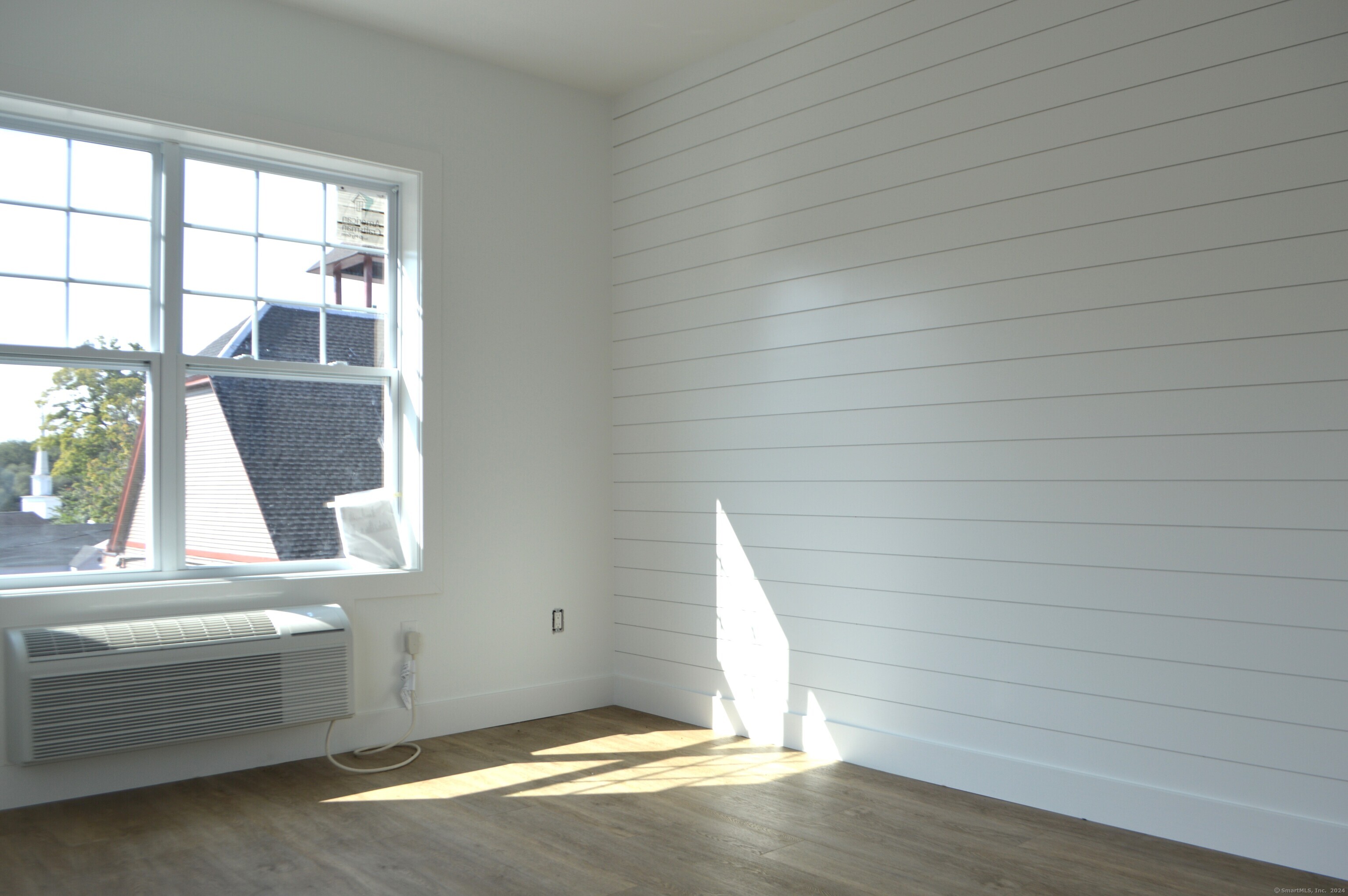 25 Church Street, Unit 106 New Milford, CT 06776 - Photo 8 of 11 an empty room with wooden floor and windows