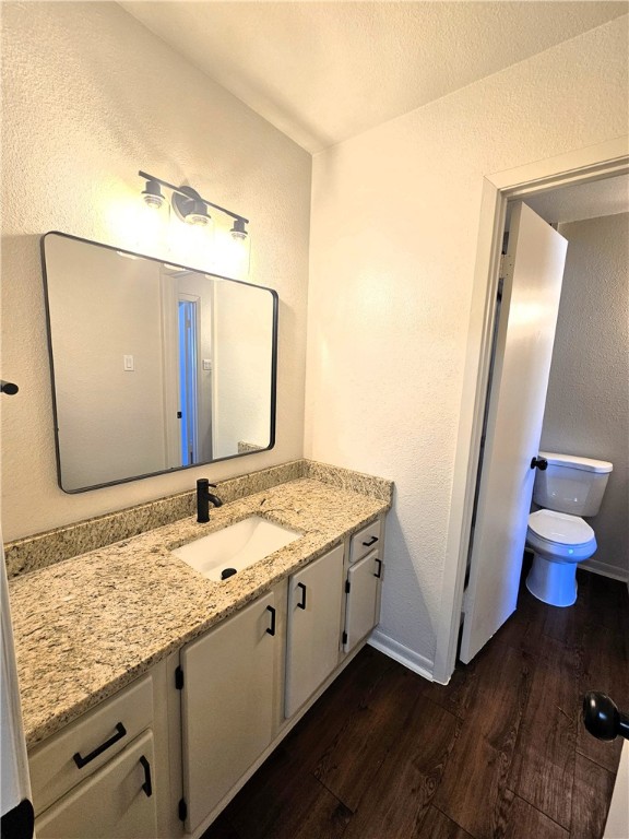 4816 Delwood Street, Unit 3 Corpus Christi, TX 78413 - Photo 12 of 19 a bathroom with a granite countertop sink a toilet and a mirror
