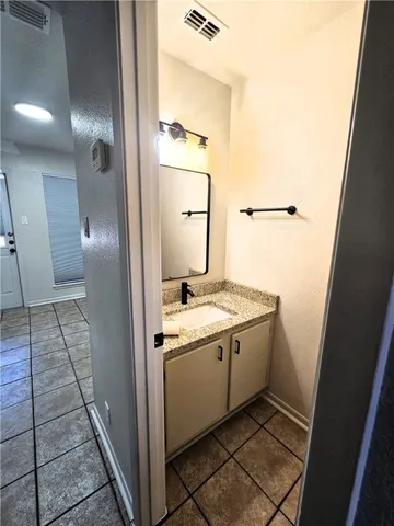 a bathroom with a granite countertop sink and a mirror