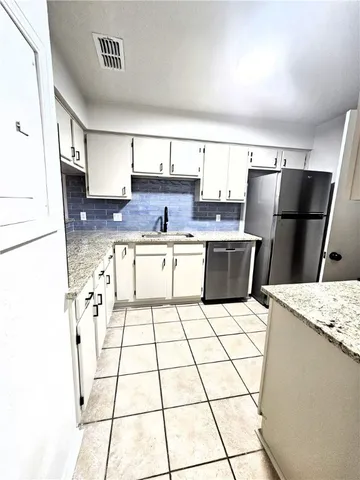 a kitchen with stainless steel appliances a sink a counter top space and cabinets