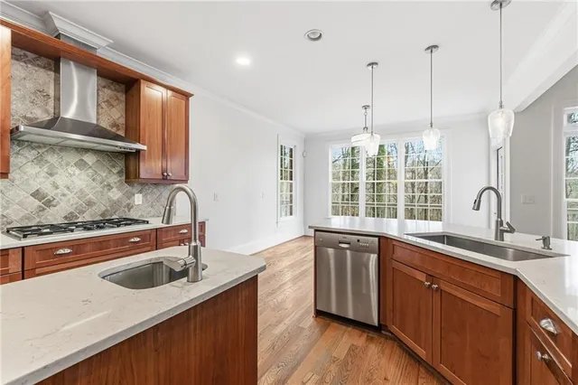 a view of an empty room with wooden floor fire place and a window