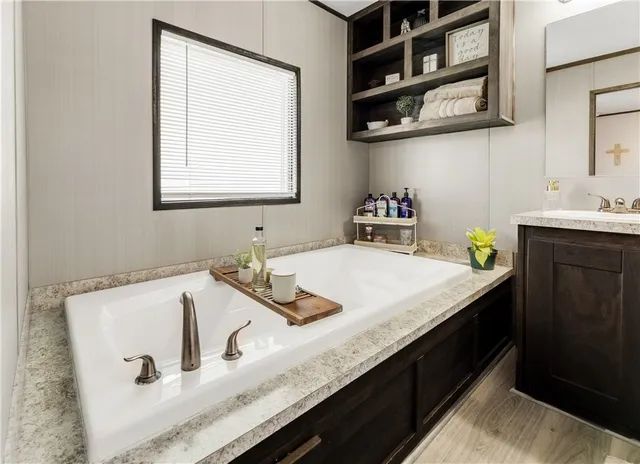 a bathroom with a granite countertop sink a vanity and a window