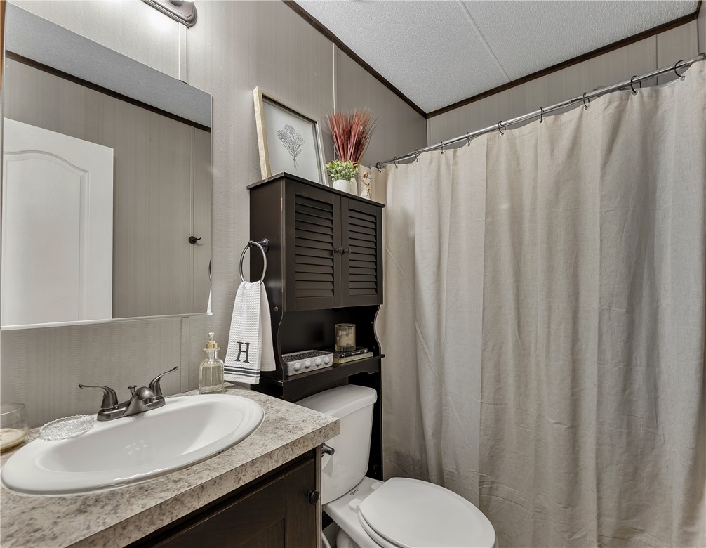 3133 Henderson Road Navasota, TX 77868 - Photo 20 of 26 a bathroom with a granite countertop sink toilet and a mirror