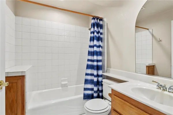 a bathroom with a bathtub shower sink vanity and toilet