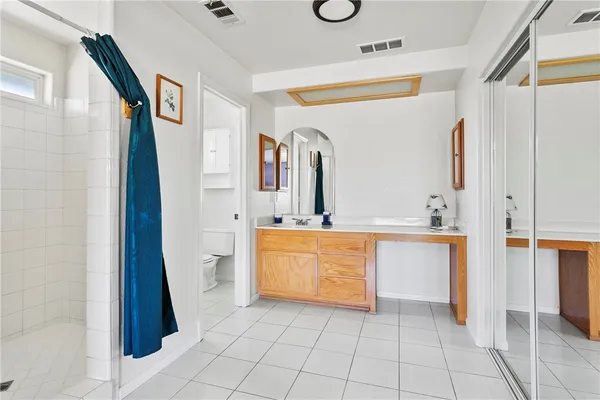 a bathroom with a granite countertop sink a mirror and a bathtub