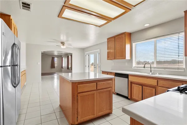 a kitchen with stainless steel appliances granite countertop a sink counter space cabinets and a refrigerator