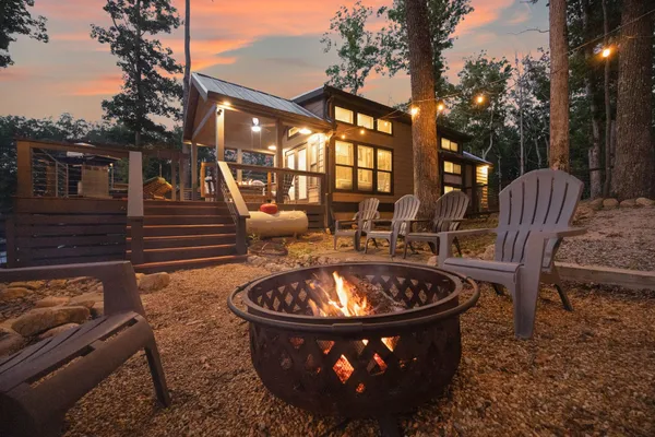 a view of a patio with couches table and chairs with wooden floor and fence