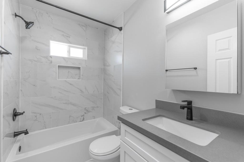 128 Bristol Boulevard San Leandro, CA 94577 - Photo 11 of 32 a bathroom with a granite countertop sink a toilet and bathtub