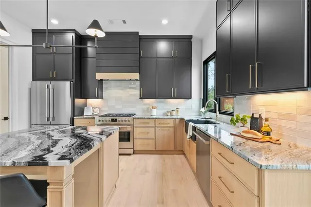 a kitchen with stainless steel appliances granite countertop a sink stove and refrigerator