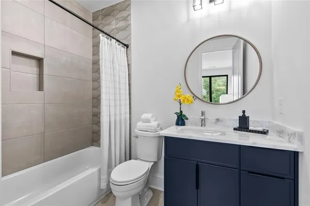 a bathroom with a bathtub sink mirror and toilet