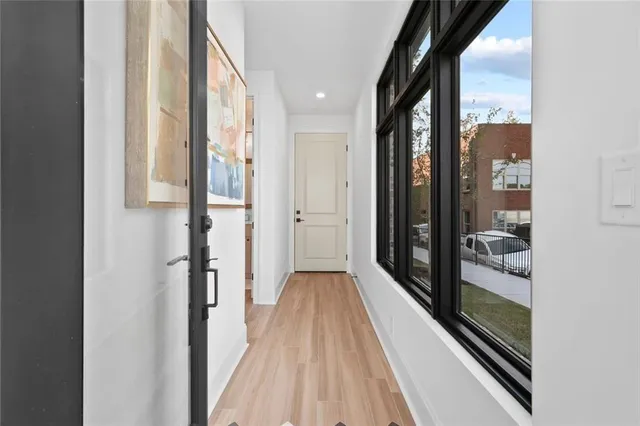 a view of a hallway with wooden floor and glass door