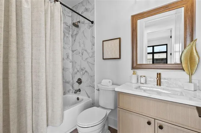 a bathroom with a granite countertop sink toilet a mirror a vanity and shower