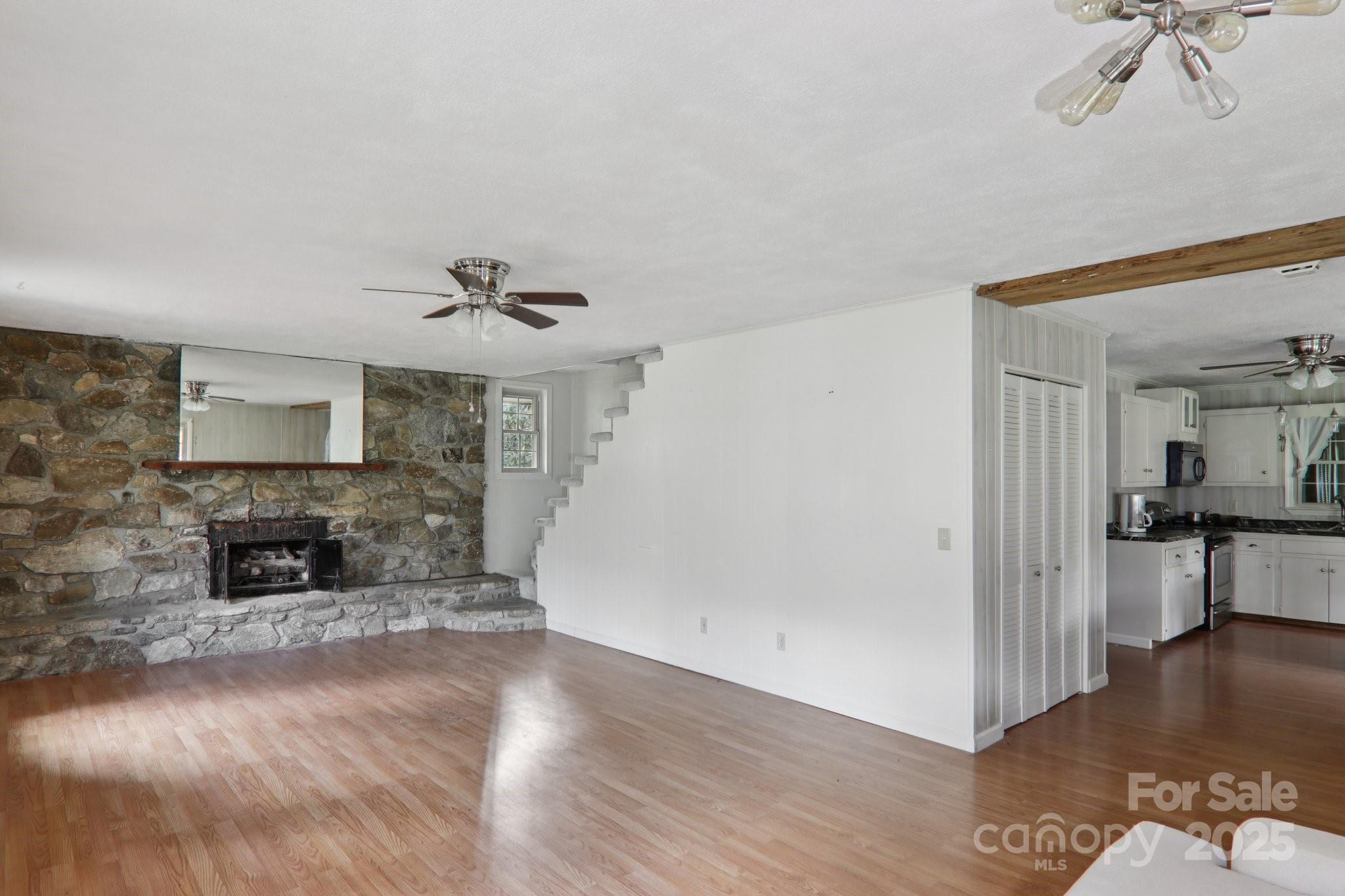190 Turkey Creek Road Clyde, NC 28721 - Photo 16 of 48 a view of a livingroom with wooden floor a fireplace and window