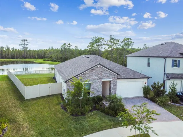 an aerial view of a house with garden space and a swimming pool