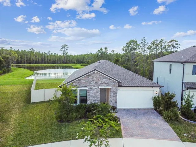 an aerial view of a house with a garden and lake view