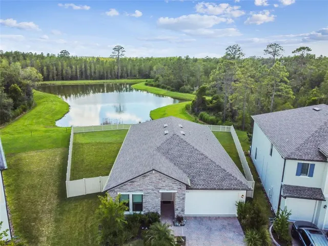 an aerial view of a house with a garden and lake view