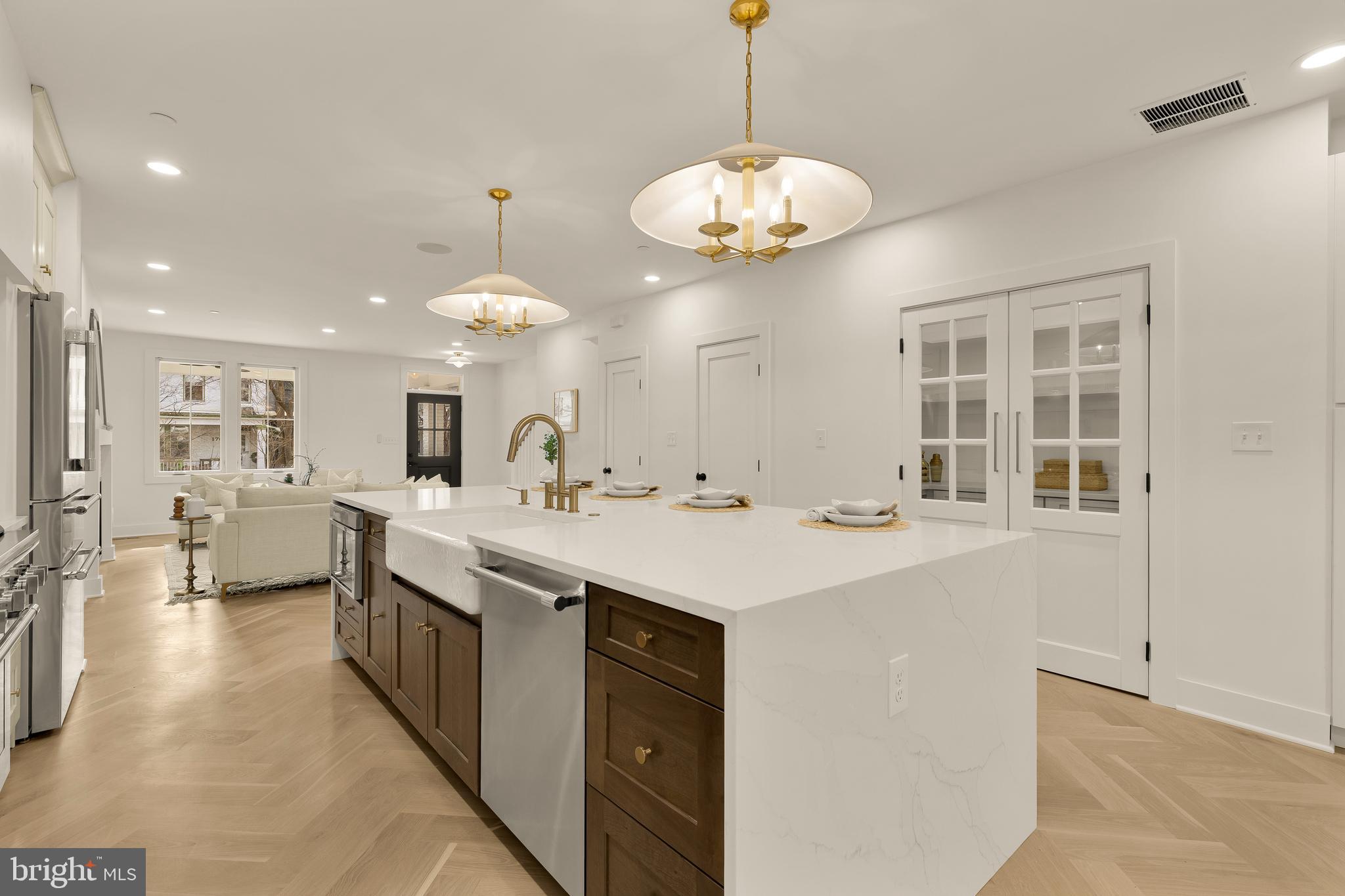 1706 Bay Street Southeast Washington, DC 20003 - Photo 22 of 59 a large white kitchen with a large island oven a stove and a chandelier