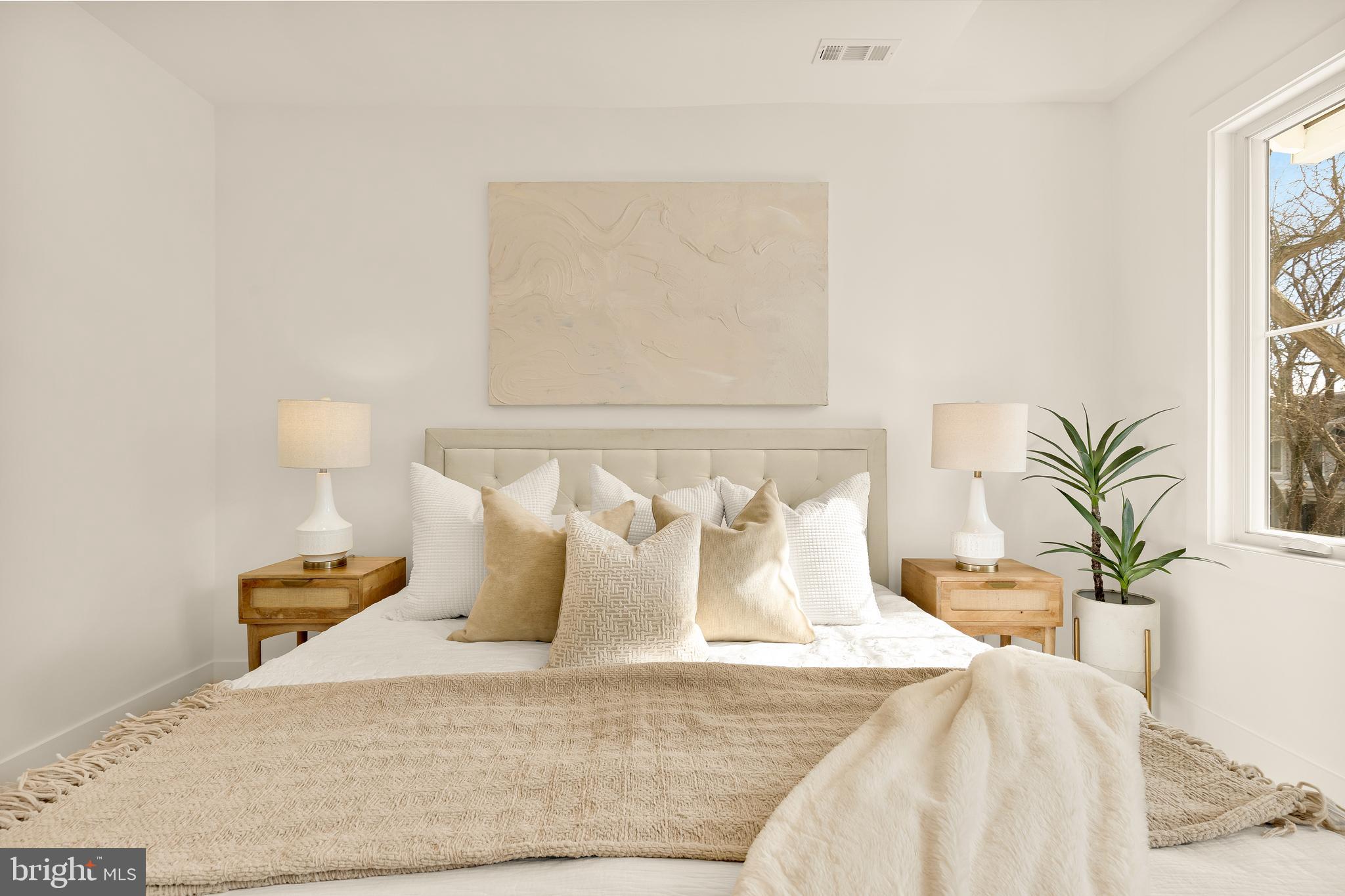 1706 Bay Street Southeast Washington, DC 20003 - Photo 39 of 59 a bedroom with a bed and lamps potted plants next to a large window