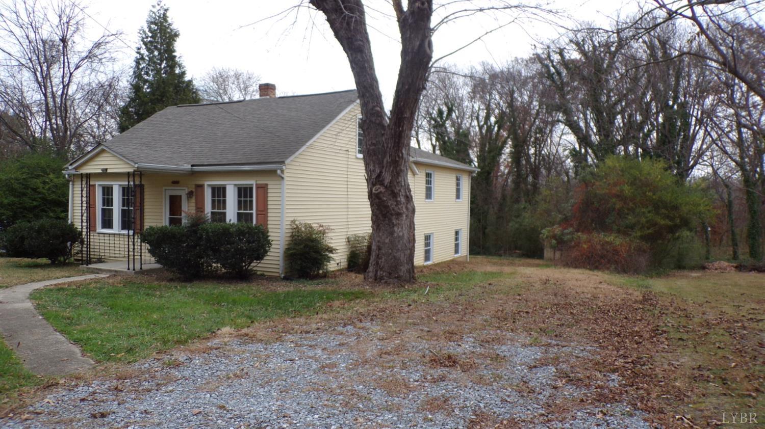 a view of a house with backyard and a tree