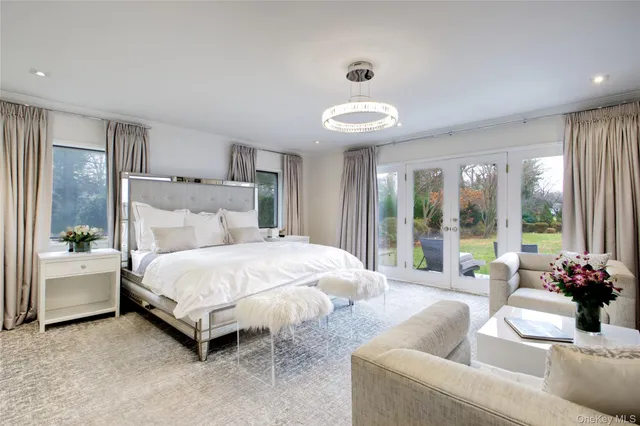 a bedroom with a bed and large windows