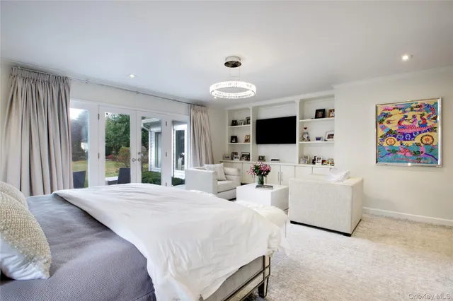 a large bedroom with a large bed and a flat screen tv