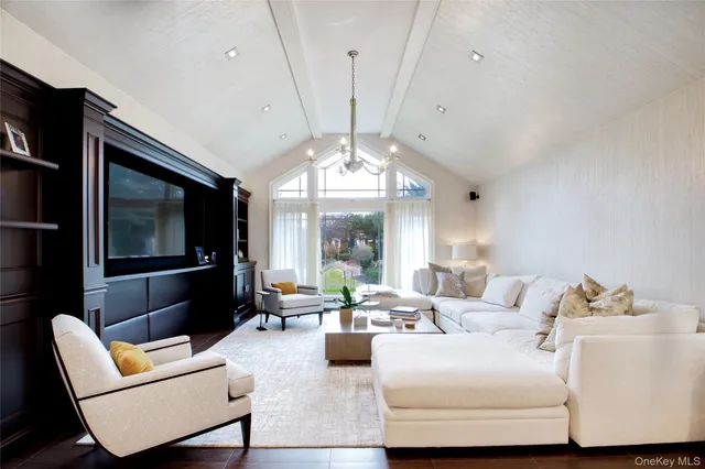 a living room with furniture a chandelier and a large window