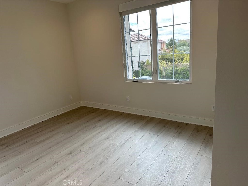104 San Benito Irvine, CA 92618 - Photo 13 of 19 an empty room with wooden floor and windows