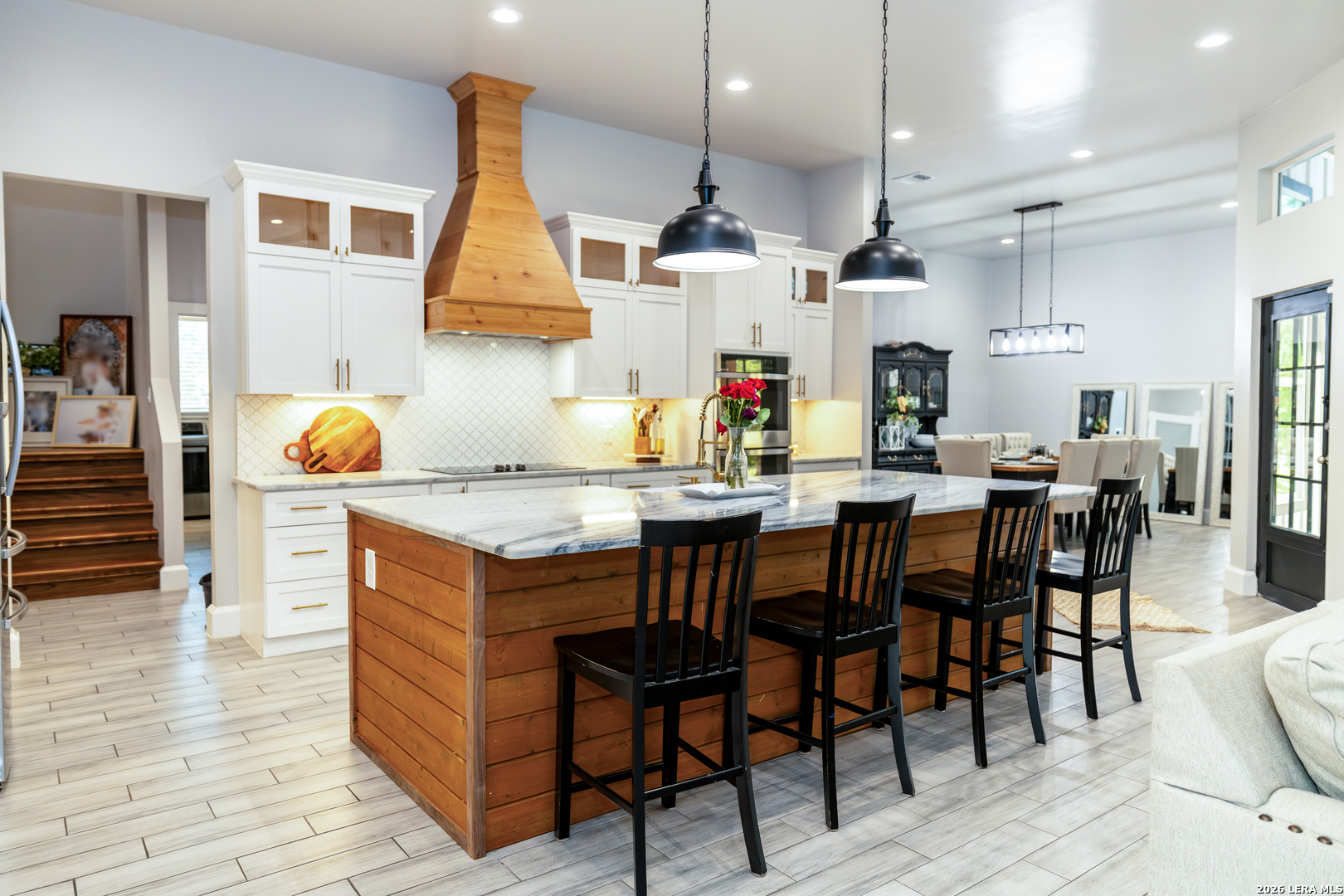 240 Eagle Rock Poteet, TX 78065 - Photo 6 of 25 a kitchen with stainless steel appliances granite countertop a table chairs and a wooden floor