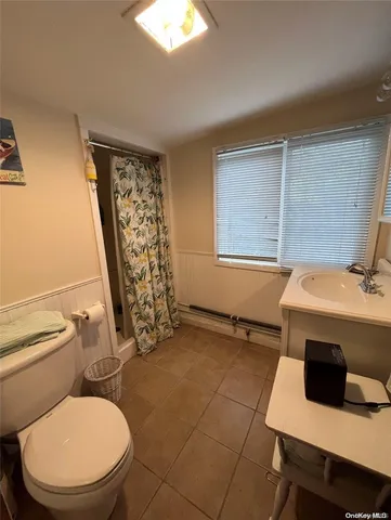 a bathroom with a sink toilet and window
