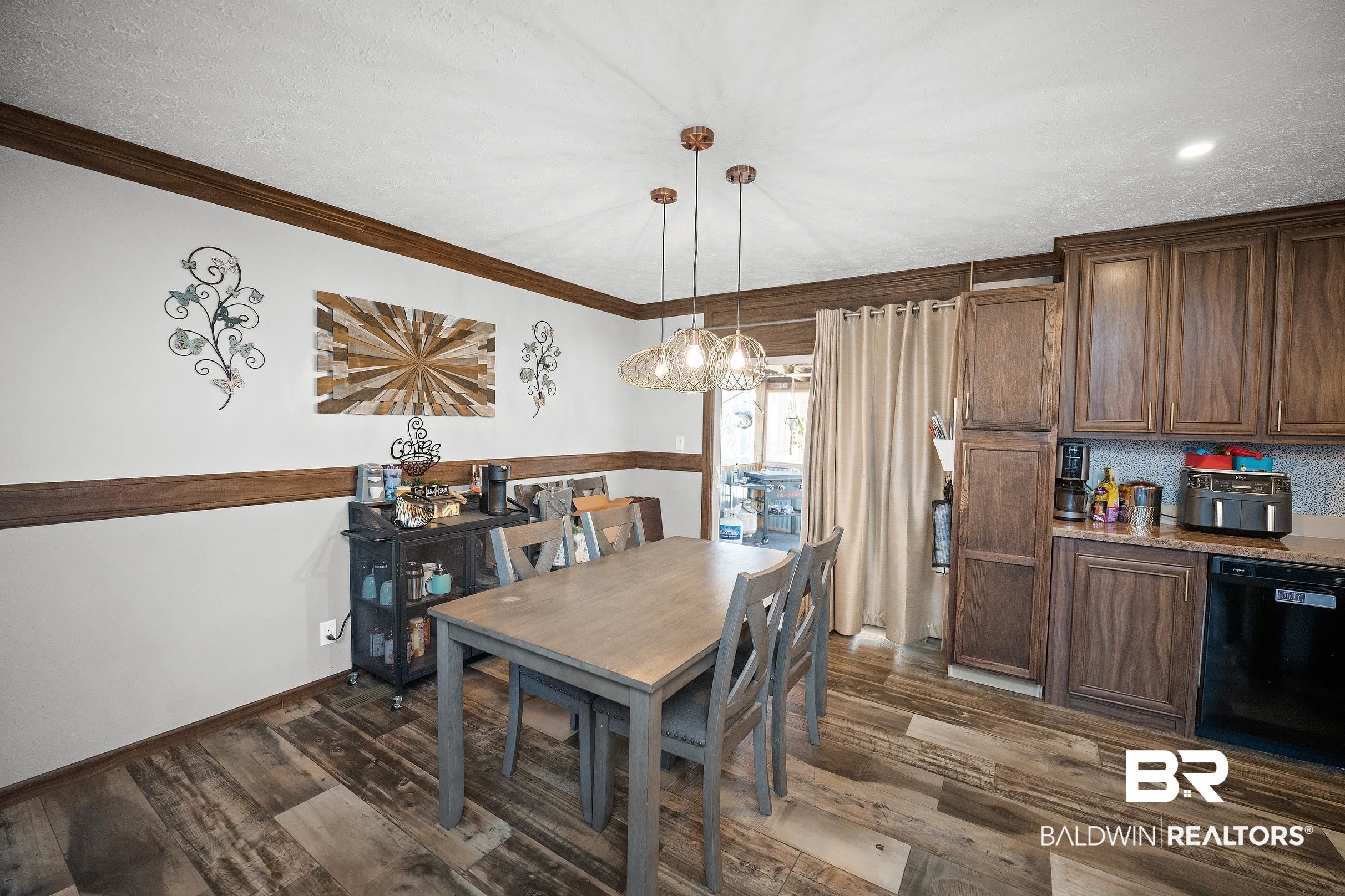 8630 Allison Lane Wilmer, AL 36587 - Photo 11 of 31 Dining area with dark wood-style floors, a chandelier, a textured ceiling, and ornamental molding
